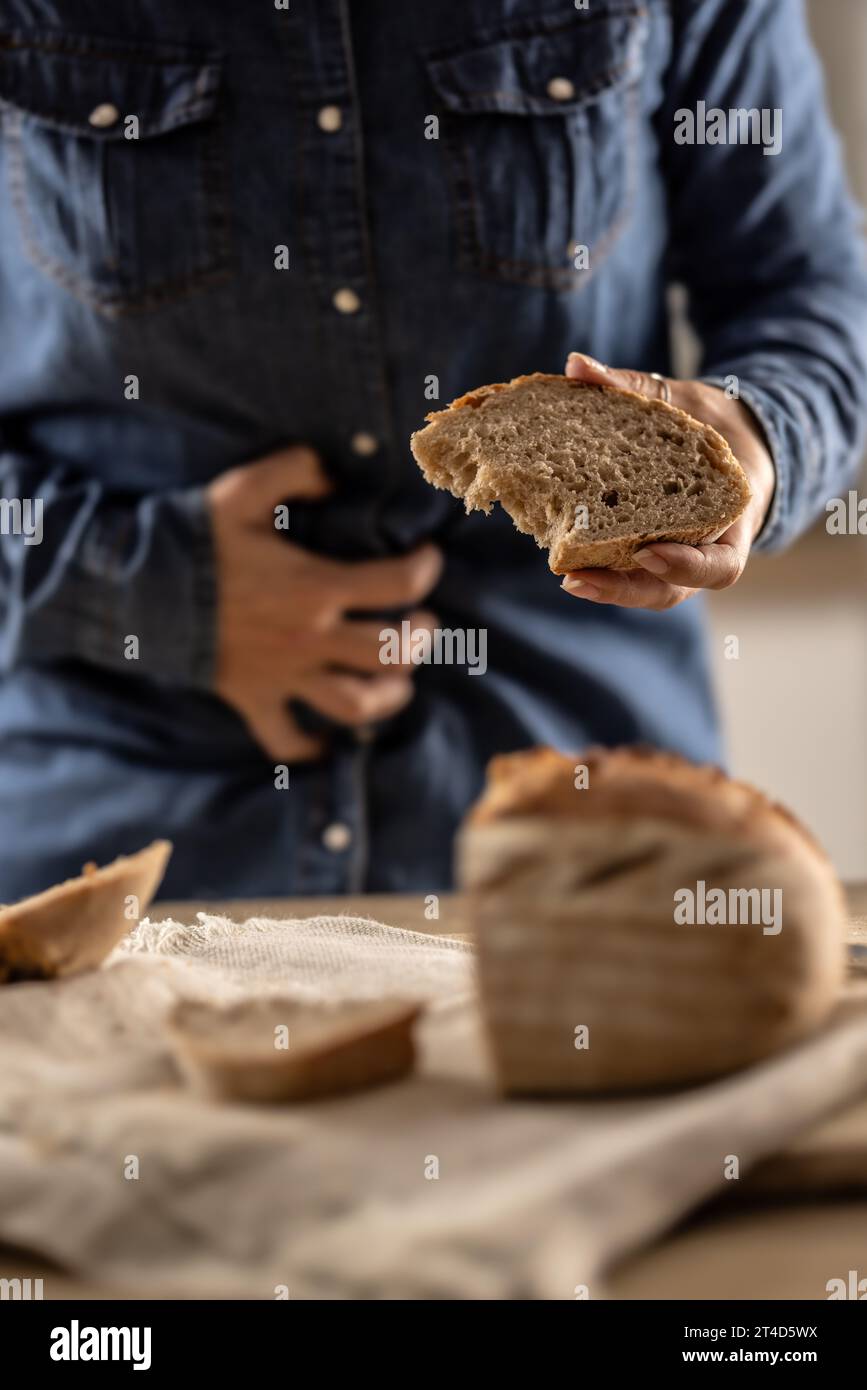 La donna non può mangiare pane e prodotti a base di cereali a causa dell'intolleranza al glutine. Una giovane celiaca soffre di dolore addominale dopo aver mangiato pane fresco. Foto Stock