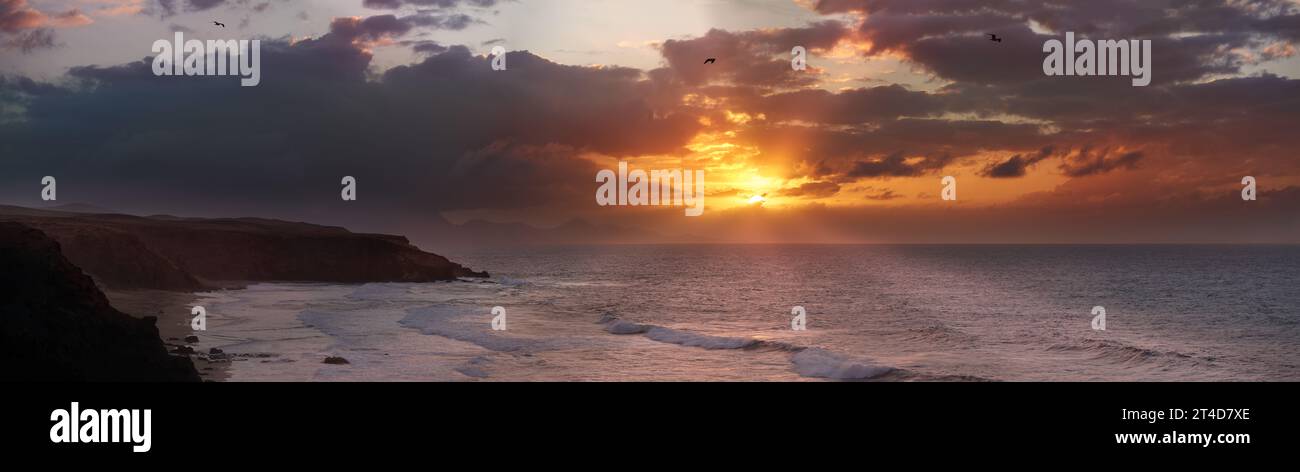 Tramonto di colore arancione con spettacolari nuvole scure sulla spiaggia di la Pared, Fuerteventura Foto Stock
