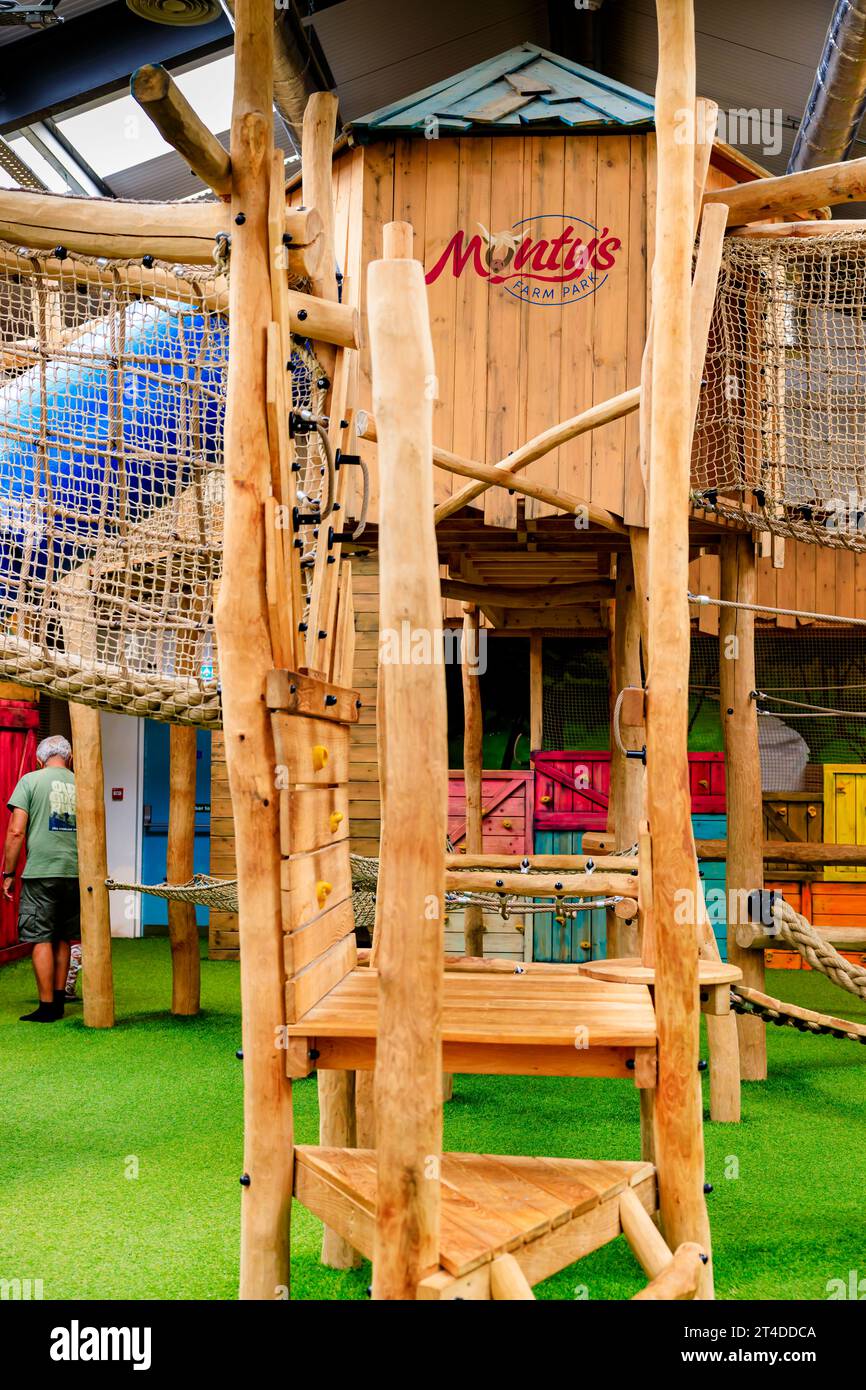 Vista ravvicinata interna di alcune strutture e del logo Monty's all'interno del Monty's Play Barn con area giochi e arrampicata interna in legno su misura Foto Stock
