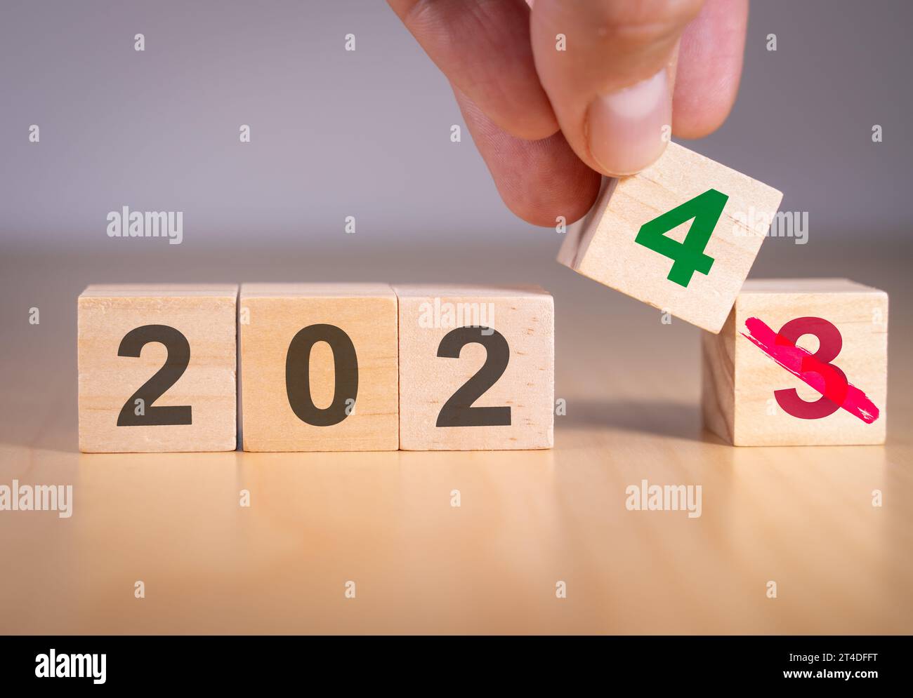 Mano che cambia il numero da 3 a 4 per simboleggiare il cambiamento dell'anno dal 2023 al 2024. Foto Stock