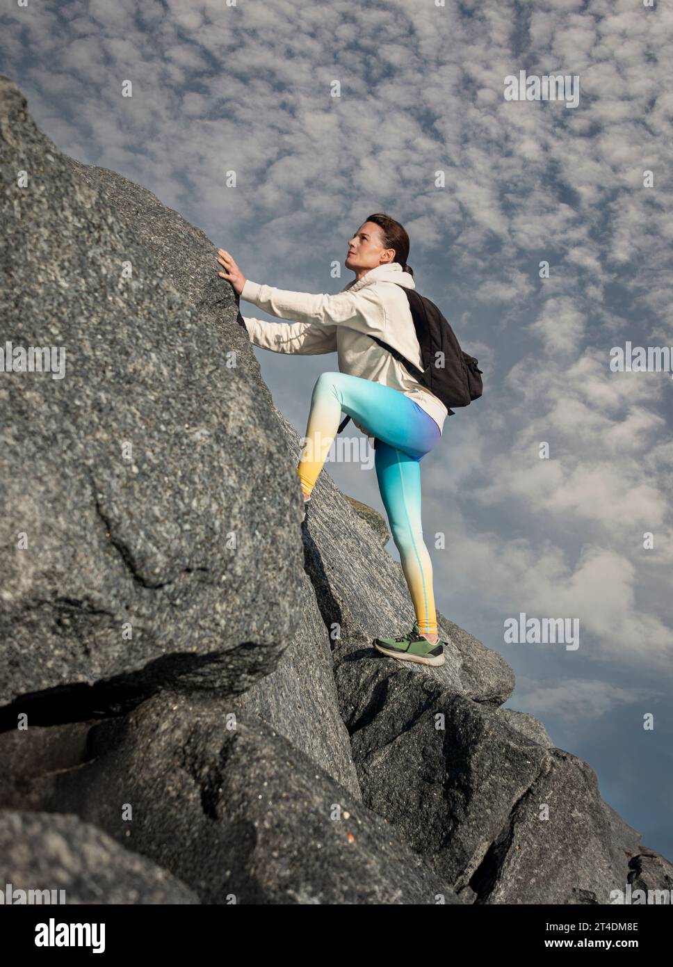 donna che sale sulle rocce Foto Stock