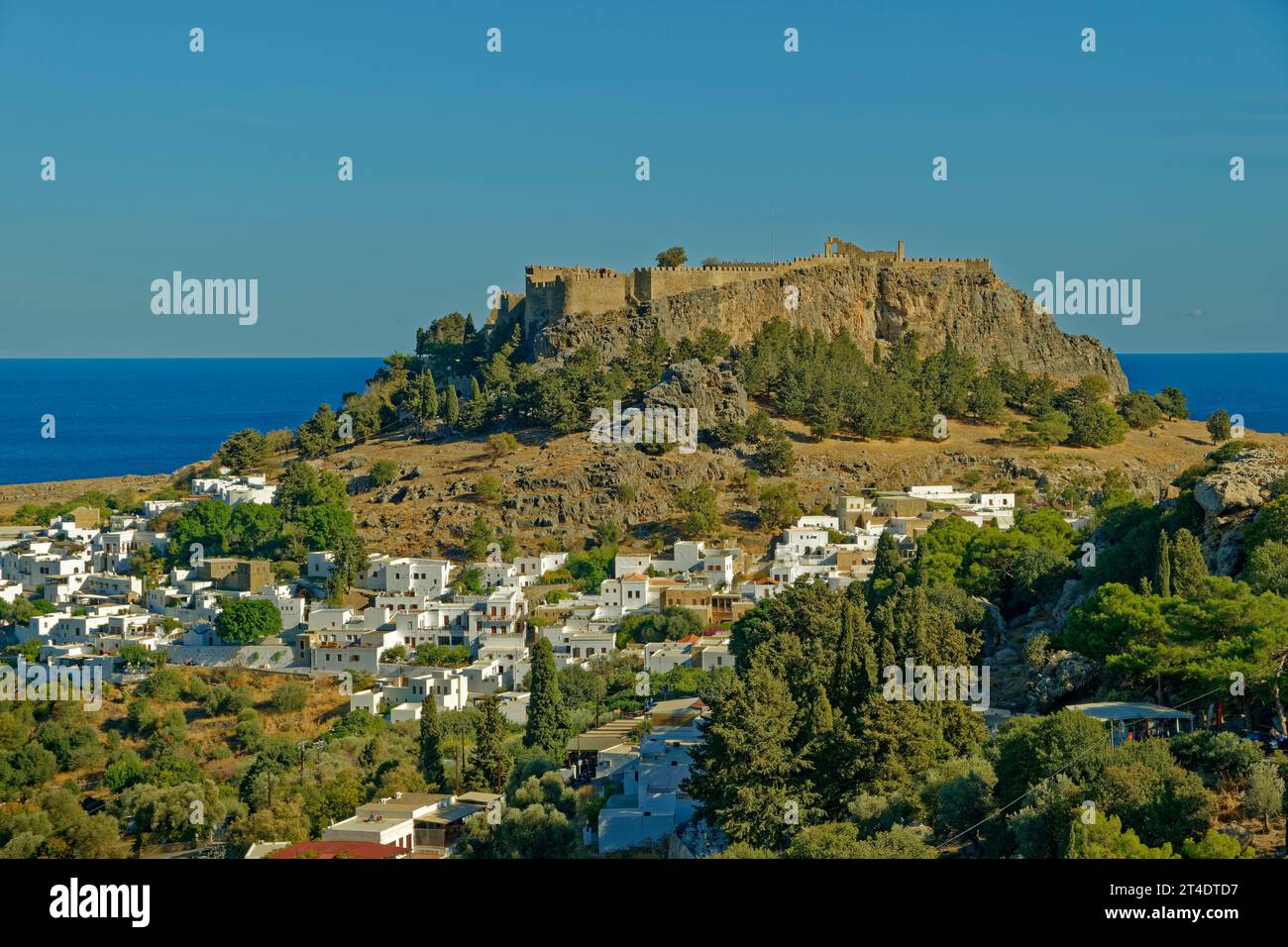 La città di Lindos sull'isola di Rodi con l'Acropoli di Lindos sul suo sito sopraelevato. Foto Stock