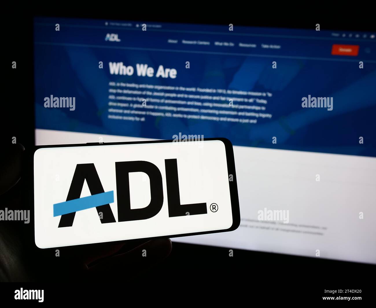 Persona che possiede uno smartphone con il logo dell'organizzazione per i diritti civili Anti-Defamation League (ADL) davanti al sito Web. Concentrarsi sul display del telefono. Foto Stock