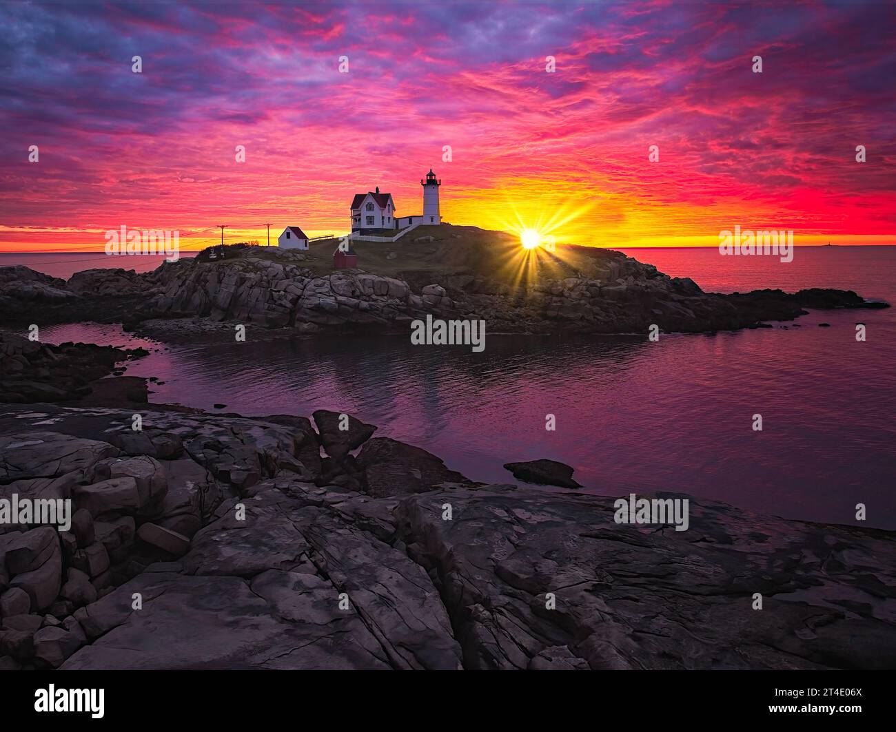 Aerial Nubble Lighthouse Sunrise - Vista aerea di uno splendido cielo con il sole che sorge dietro l'iconica Nubble Light per antonomasia. Foto Stock