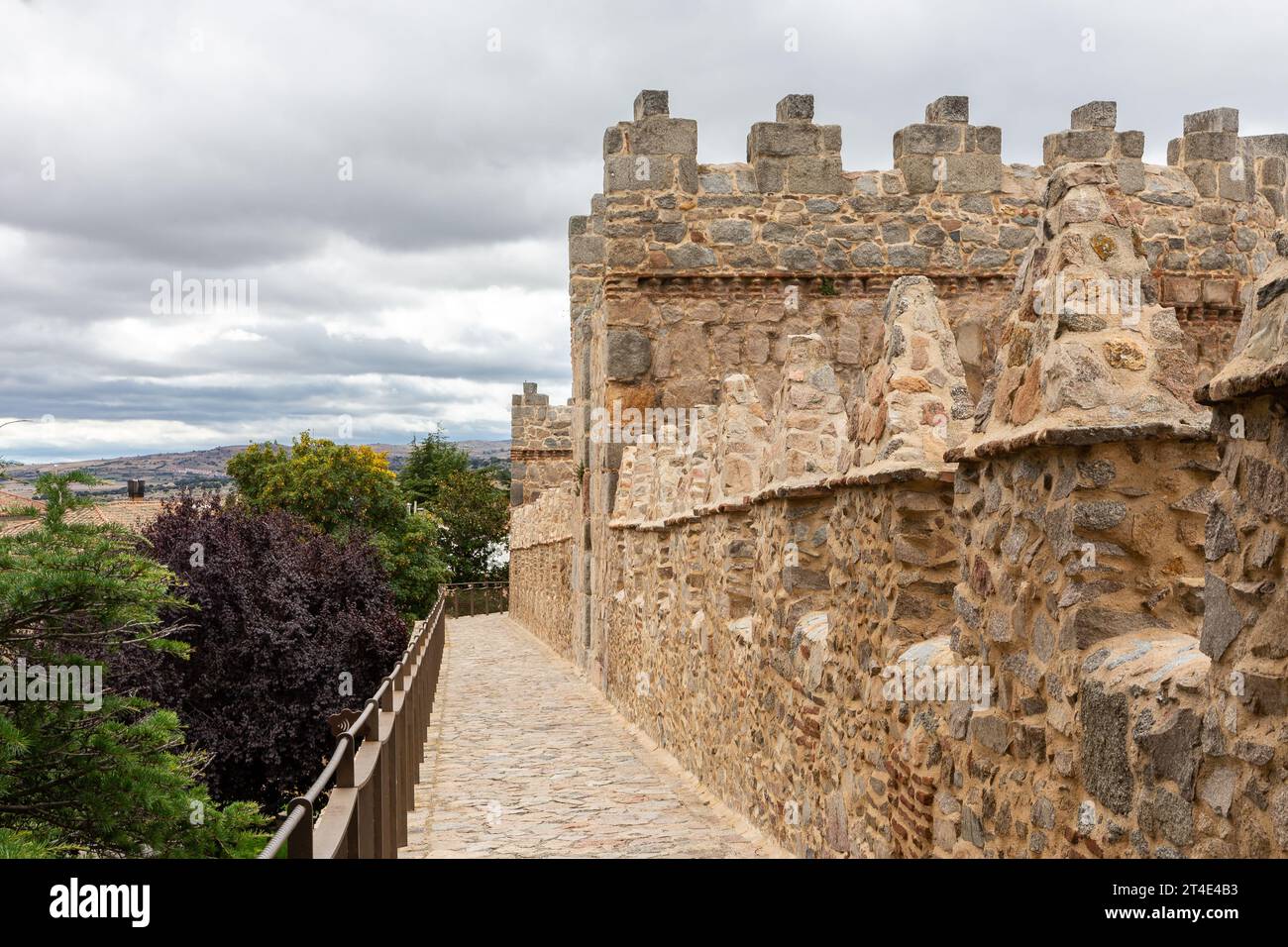 Mura di Avila (Muralla de Avila), Spagna, mura romaniche medievali in pietra con torri, merlature e sentieri in pietra che si affacciano su colline e colline Foto Stock