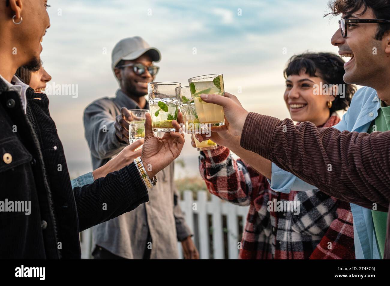 Amici allegri con bevande estive - un gruppo di amici allegri che si alzano bicchieri pieni di bevande rinfrescanti, brindano a divertirsi all'aria aperta con una c Foto Stock