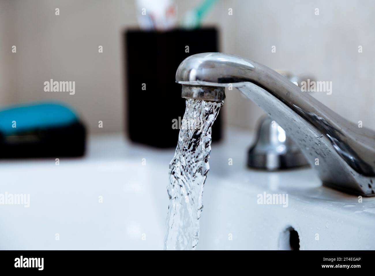 Rubinetto d'acqua in bagno. Rubinetto aperto con acqua corrente. Spreco di acqua potabile. Foto Stock