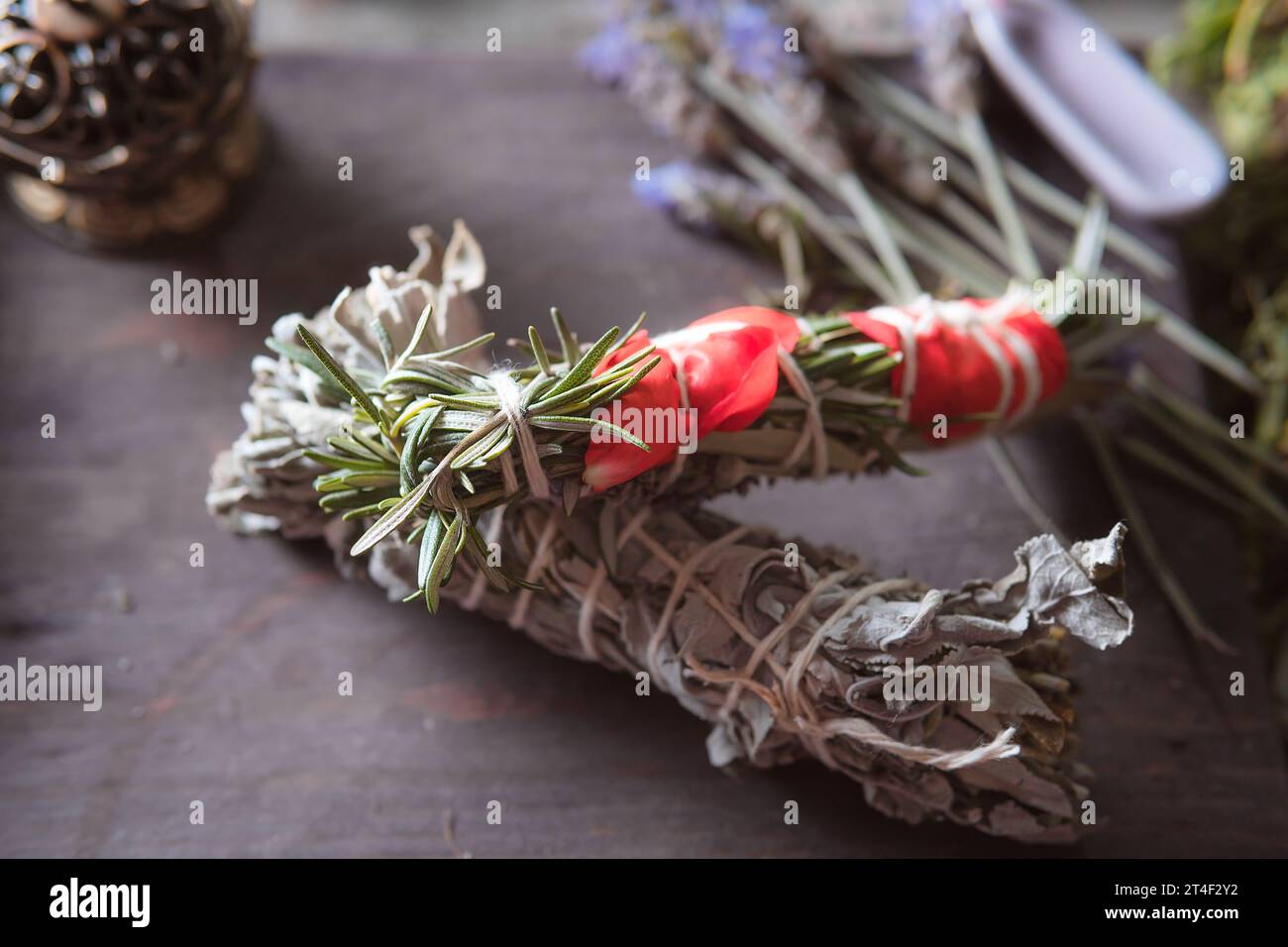 donna che fa rituale tradizionale con erbe legandole con filo di cotone accompagnato da incenso Foto Stock