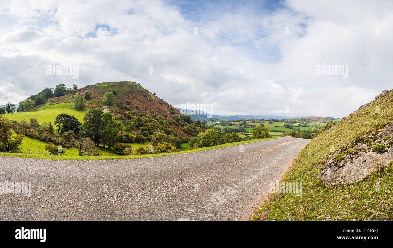 Le rovine di Castell Dinas Bran raffigurate in cima a una collina a Llangollen, nel Galles, dietro una strada curva. Foto Stock