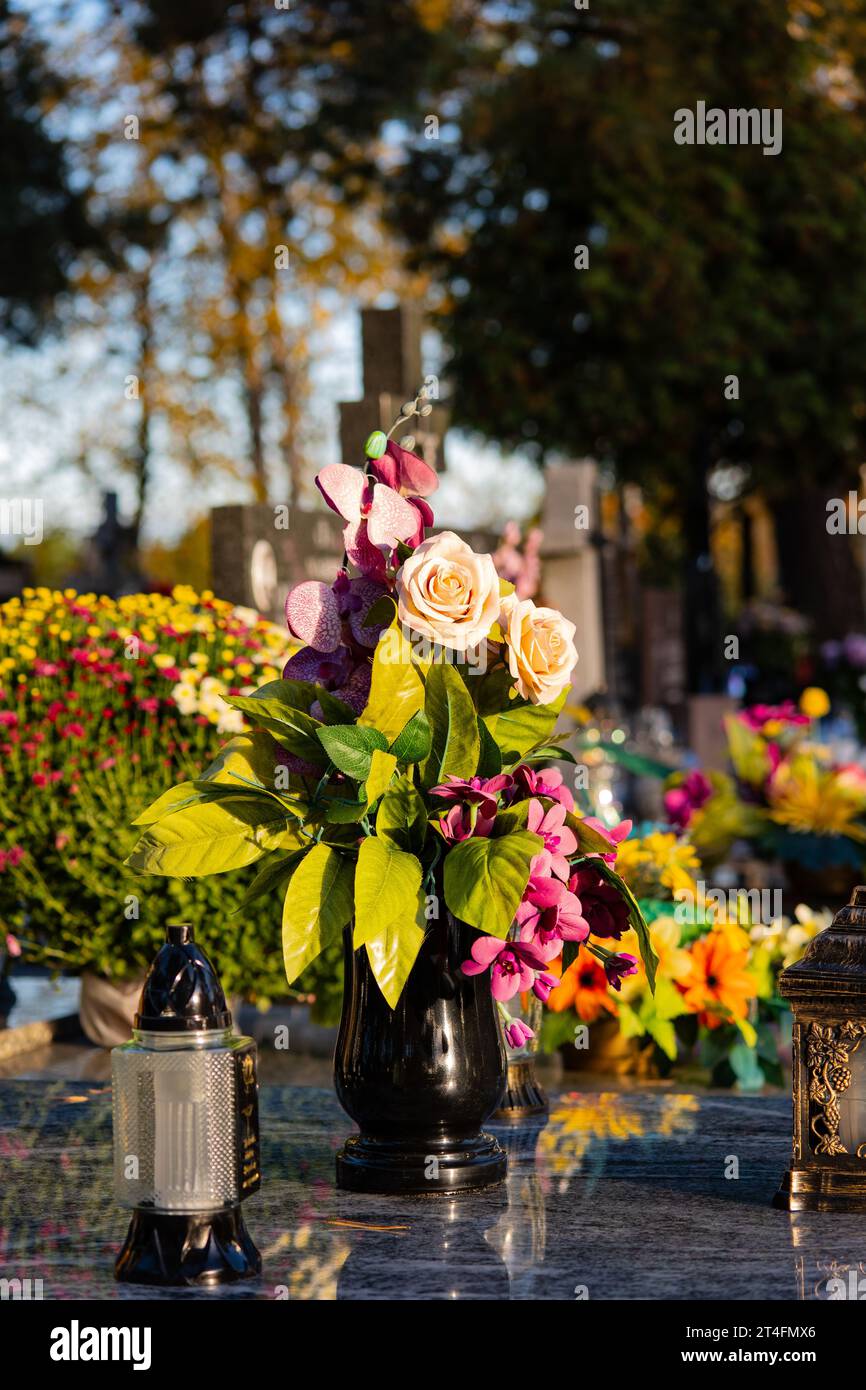 Fiori sulla tomba. Giorno di Ognissanti al cimitero. Foto Stock