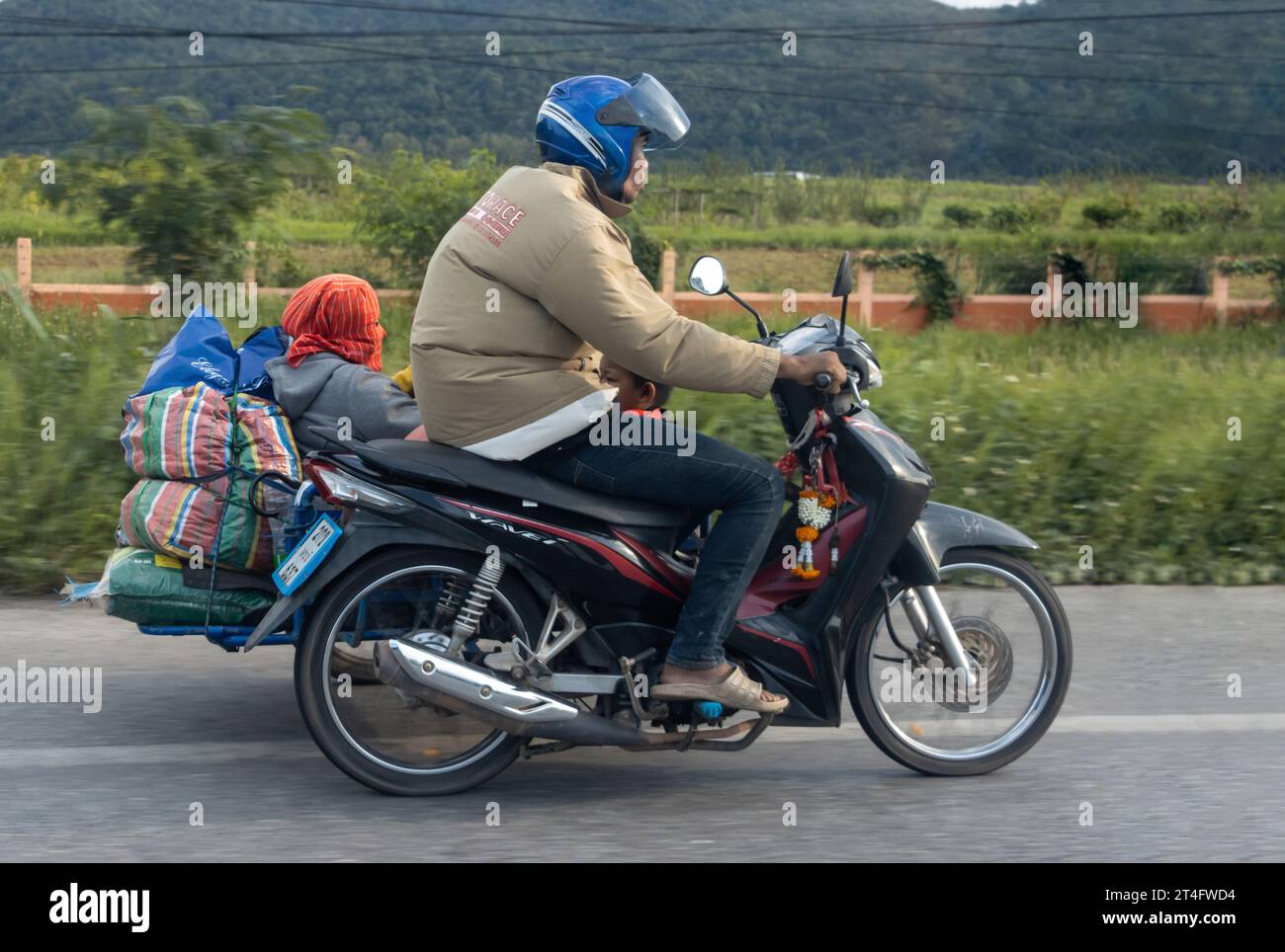 TAILANDIA, 1 ottobre 2023, Un uomo guida una moto con un sidecar su una strada locale Foto Stock