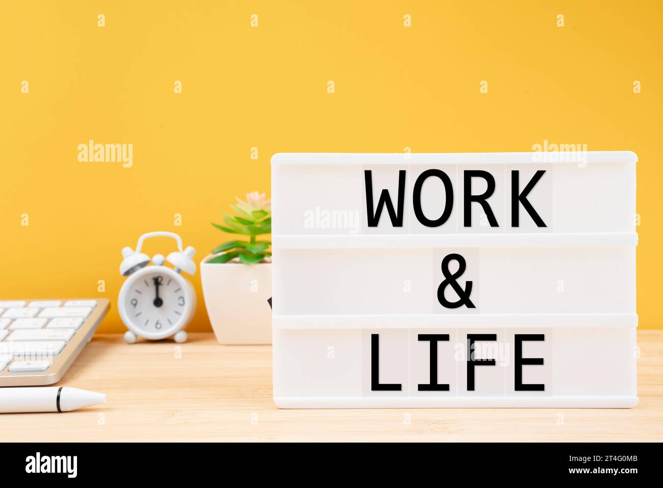 Scatola luminosa bianca scritta Work & Life sul tavolo di lavoro. Concetti di equilibrio vita lavorativa. Foto Stock