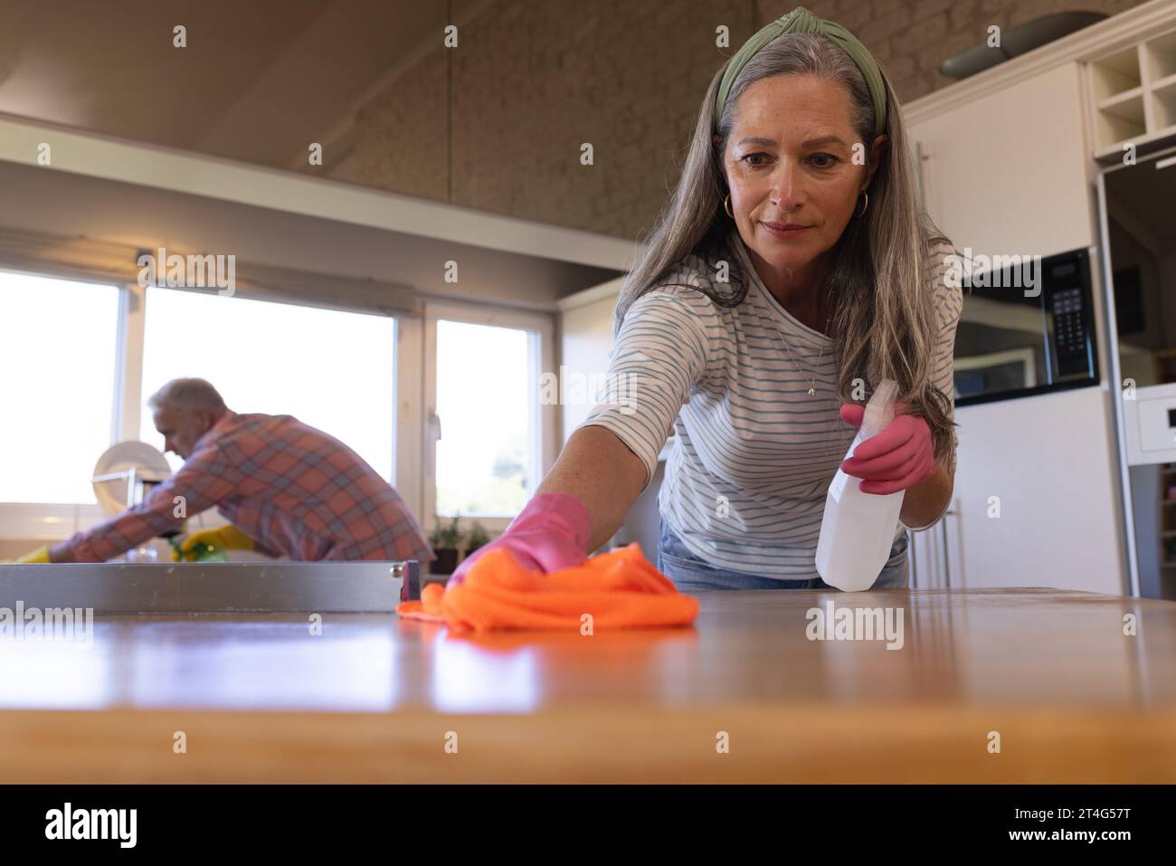 Una coppia caucasica di buon livello che pulisce il piano di lavoro in cucina a casa Foto Stock