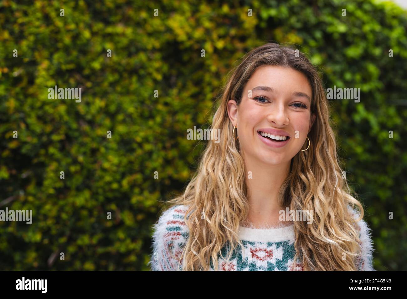 Ritratto di donna caucasica felice con lunghi capelli biondi sorridenti in giardino, spazio copia Foto Stock