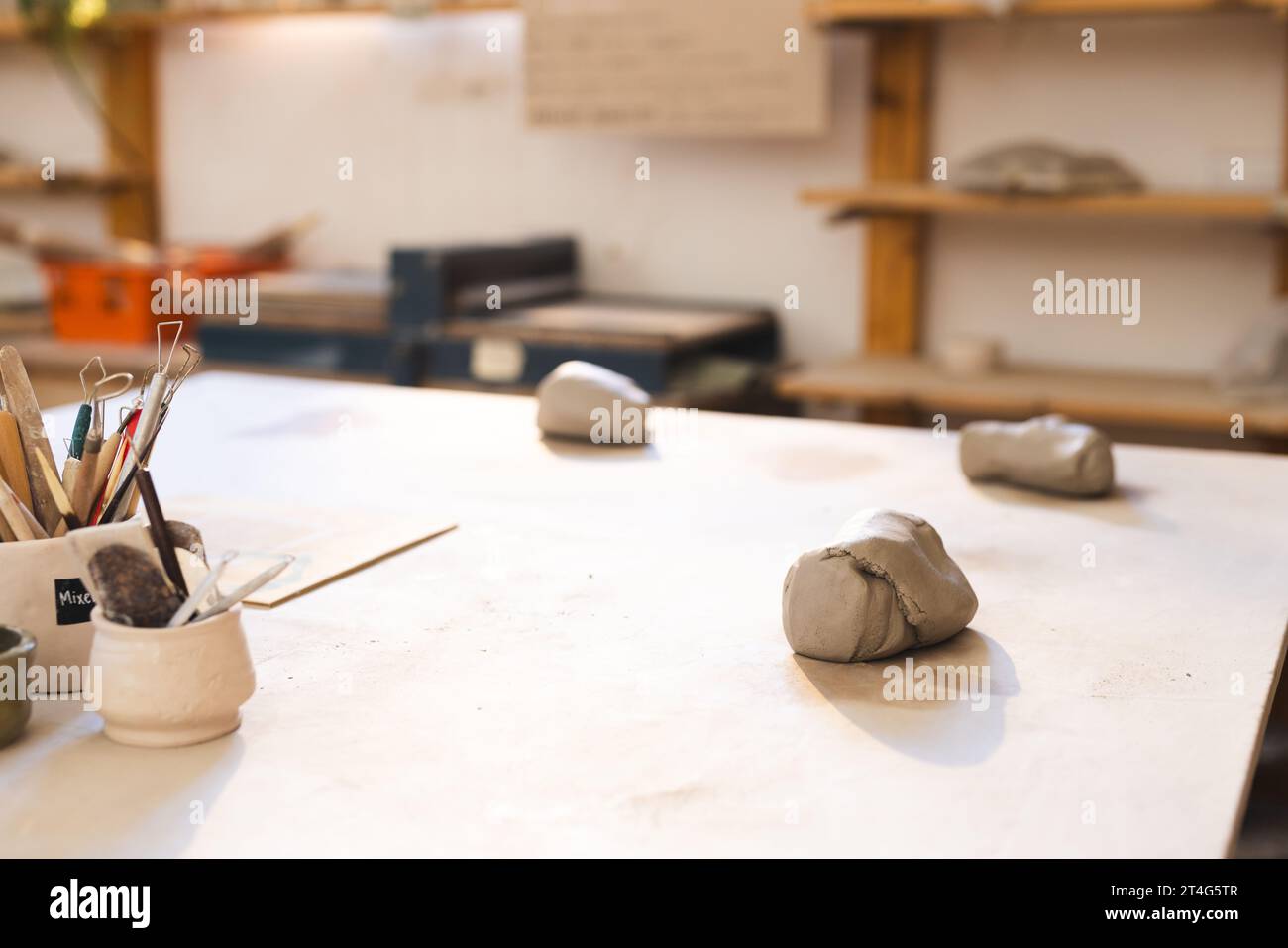 Strumenti di ceramica e argilla sdraiati sulla scrivania in uno studio di ceramica Foto Stock
