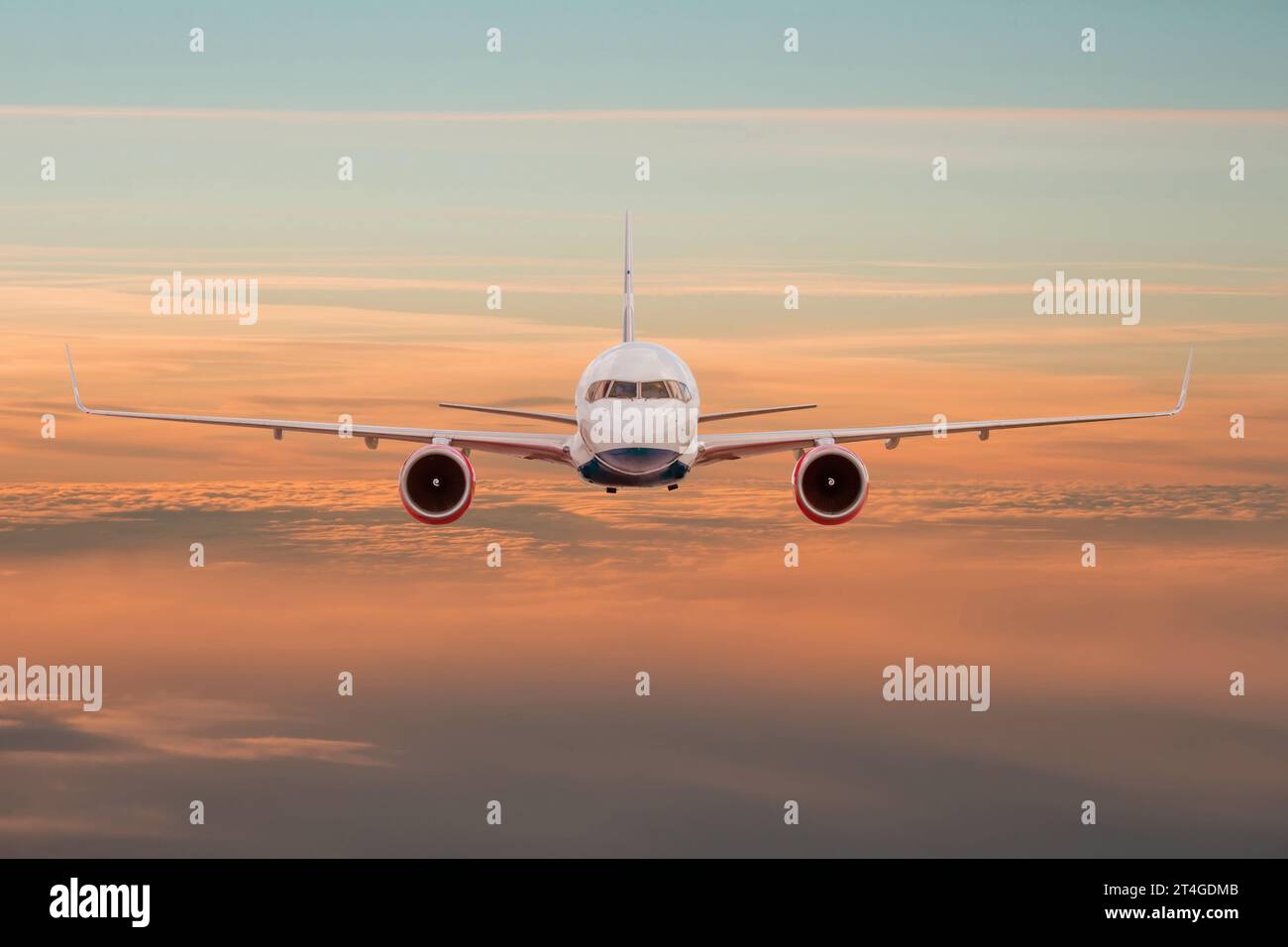 Passeggeri aereo commerciale che vola sopra le nuvole al tramonto, vista diritta. Concetto di viaggio veloce, vacanze e affari Foto Stock