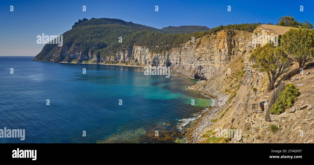 Panorama delle scogliere costiere con le cime di Bishop e Clerk in lontananza, Parco Nazionale di Maria Island, Tasmania, Australia Foto Stock