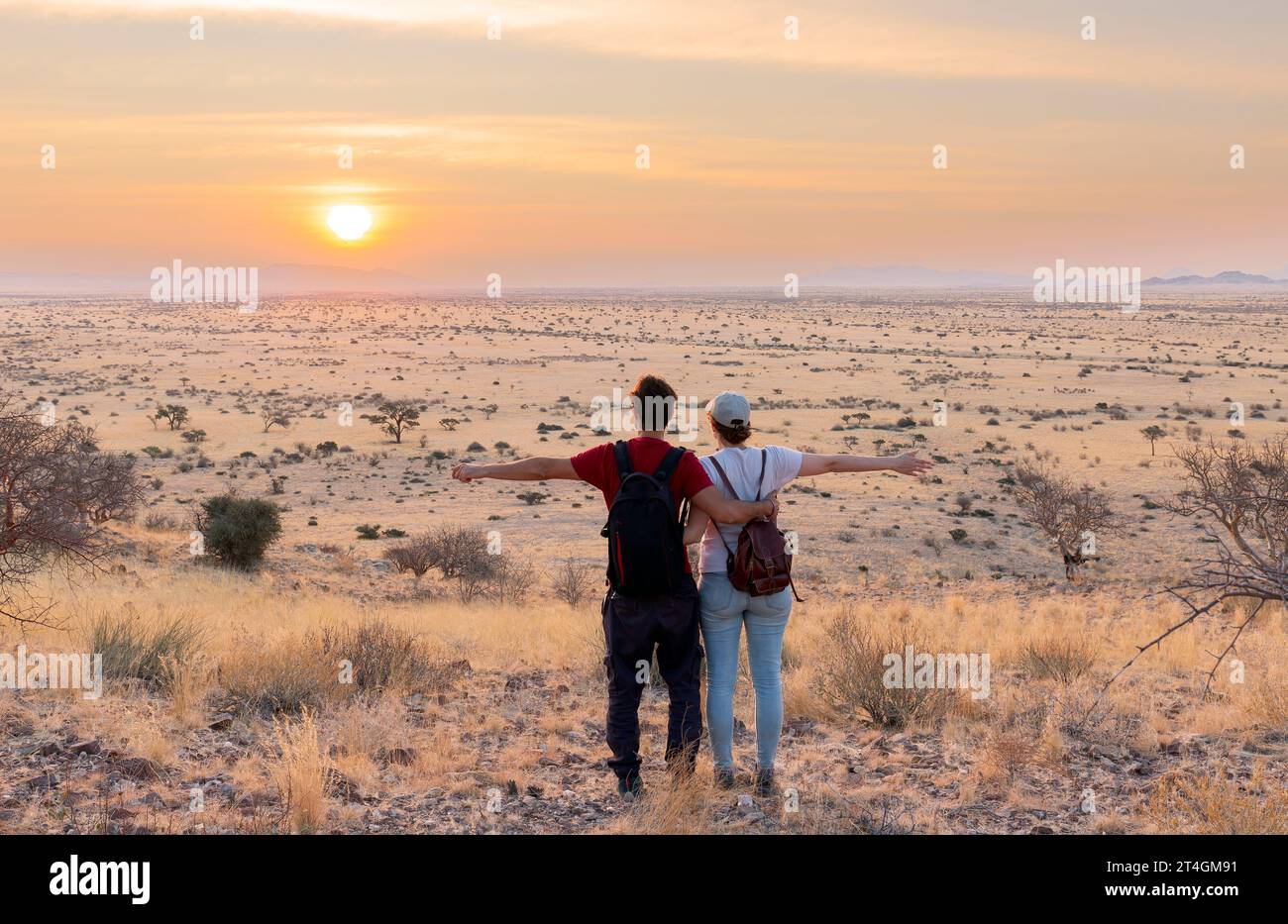 Giovani coppie che si godono il tramonto in un paesaggio africano Foto Stock