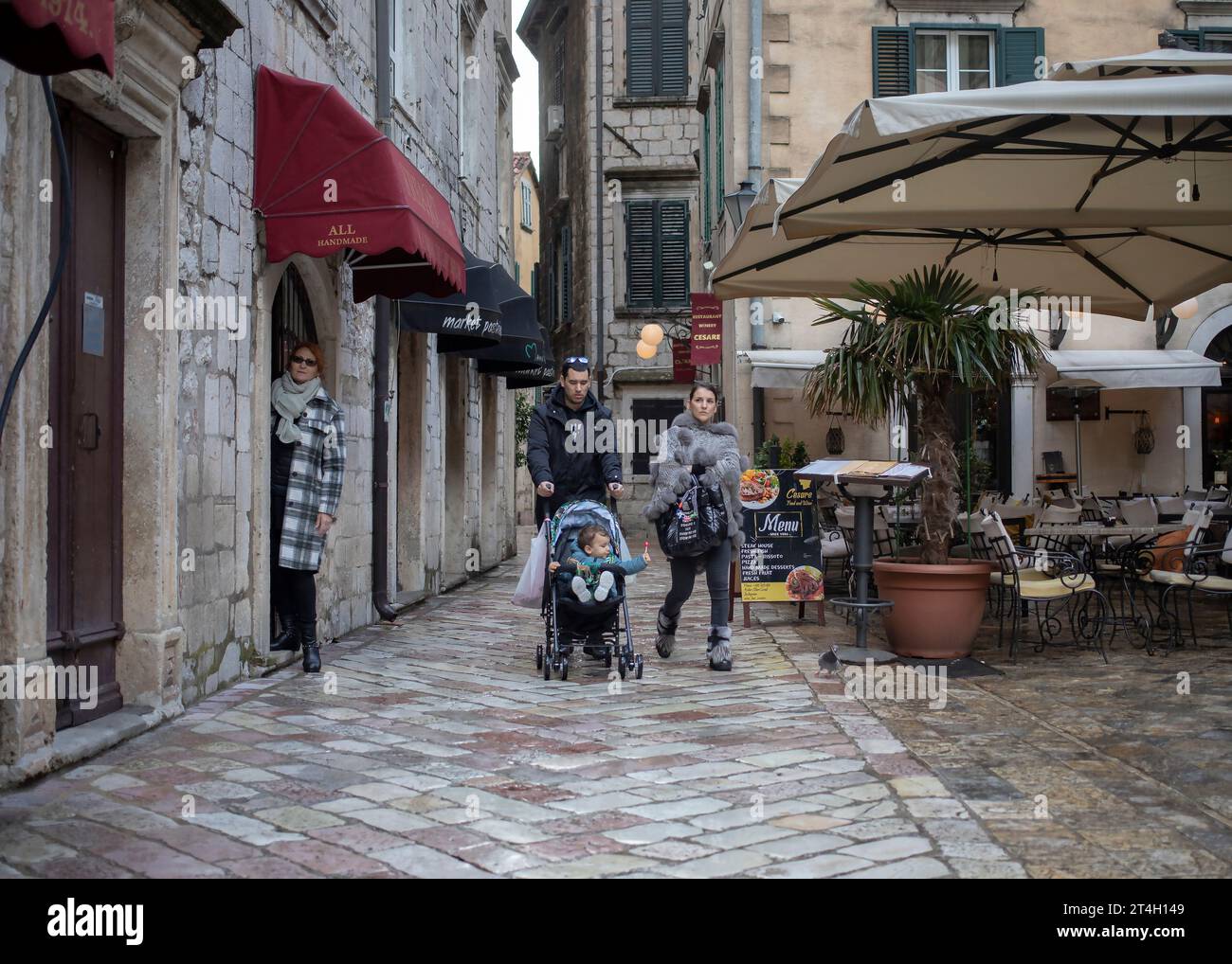 Montenegro, 15 aprile 2023: Una coppia sposata con un bambino che cammina per strada nel centro storico di Kotor Foto Stock