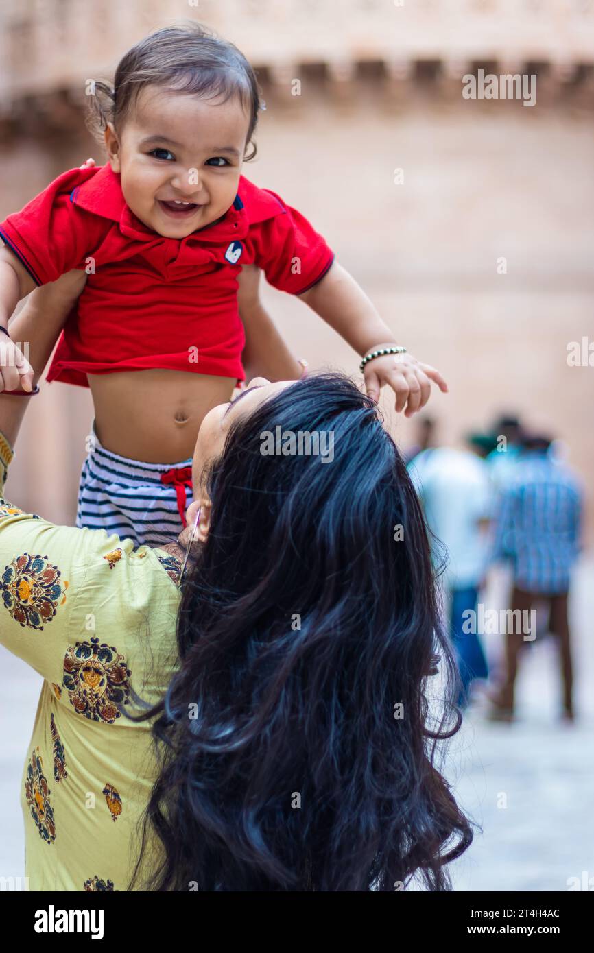 simpatico bambino sorridente alla mano della madre e con un tocco informale all'aperto Foto Stock