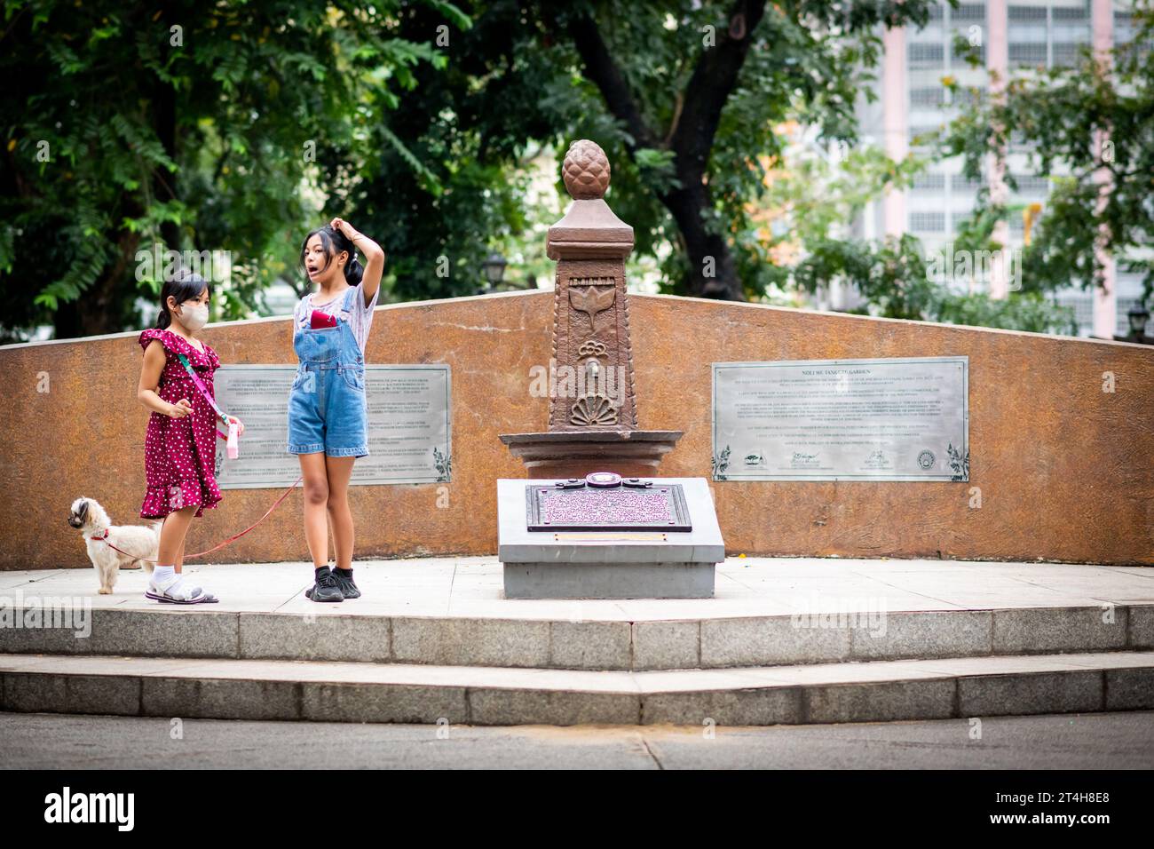 I bambini giocano intorno a una statua nel Rizal Park, Ermita, Manila, Filippine. Foto Stock