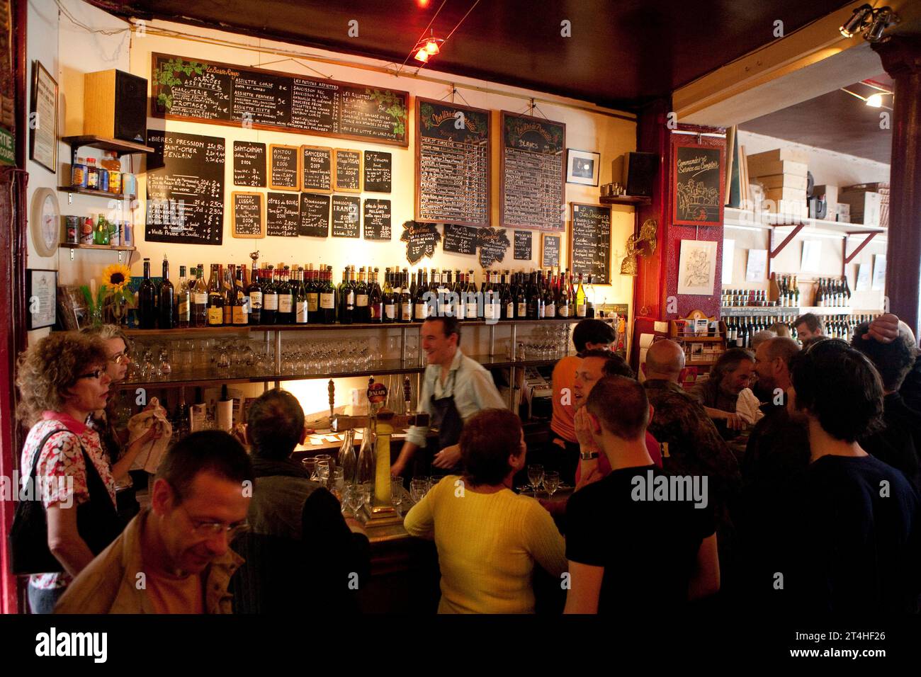 I giovani si divertono in un famoso bar e negozio di vini a Parigi, vicino a Place de la Bastille Foto Stock