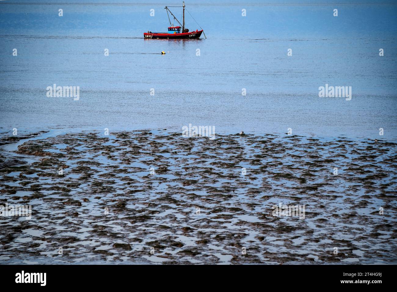 Ora azzurra autunnale di Morecambe Bay. peschereccio all'ancora. Foto Stock