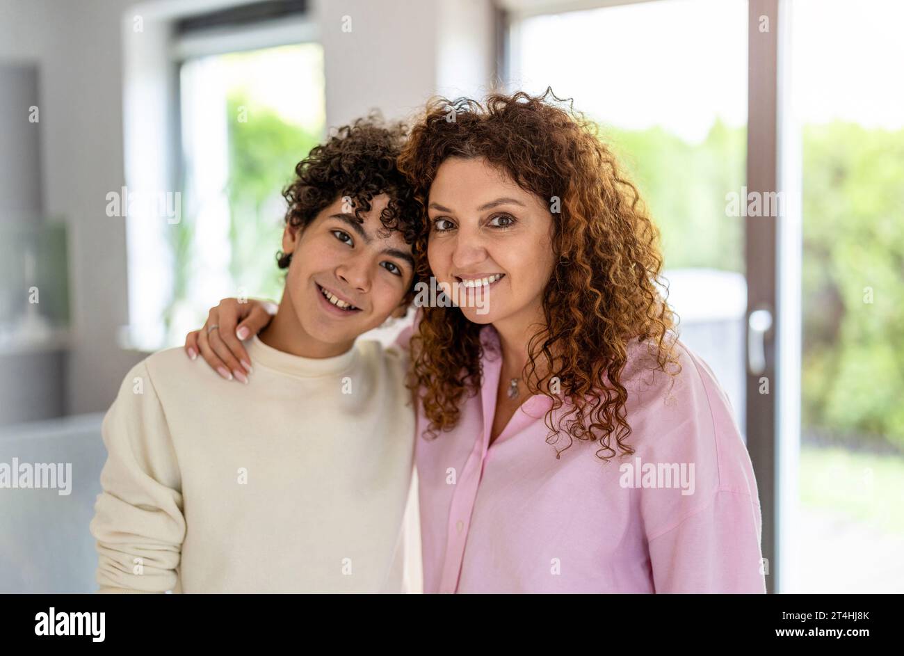 Ritratto di madre e figlio sorridenti in salotto a casa Foto Stock