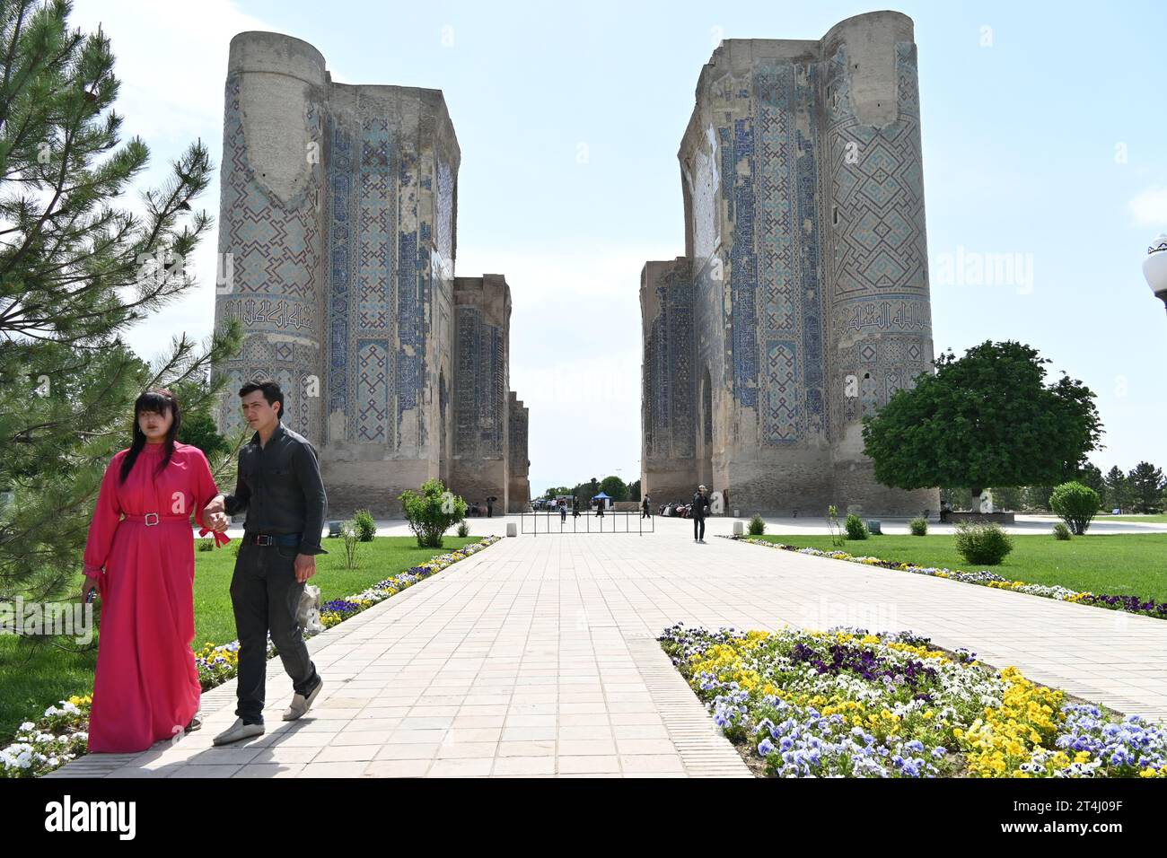 Coppia uzbeka vicino agli edifici gemelli nel Palazzo Ak-Saray a Shahrisabz, Uzbekistan Foto Stock