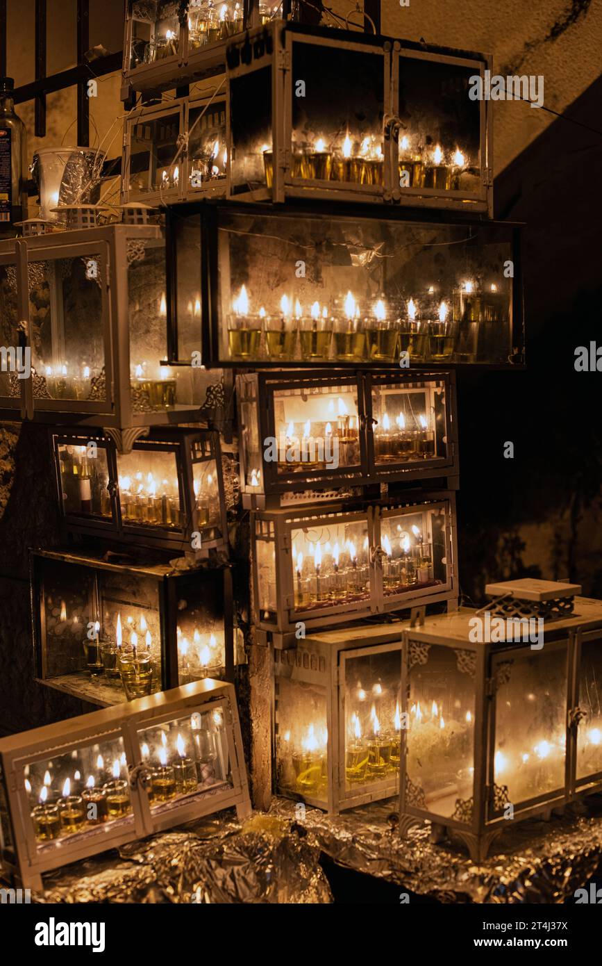 Numerose case di vetro ospitano fiale di petrolio e stoppini brucianti nelle menorah che brillano brillantemente fuori da una scuola Yeshiva l'ottava notte del f ebraico Foto Stock