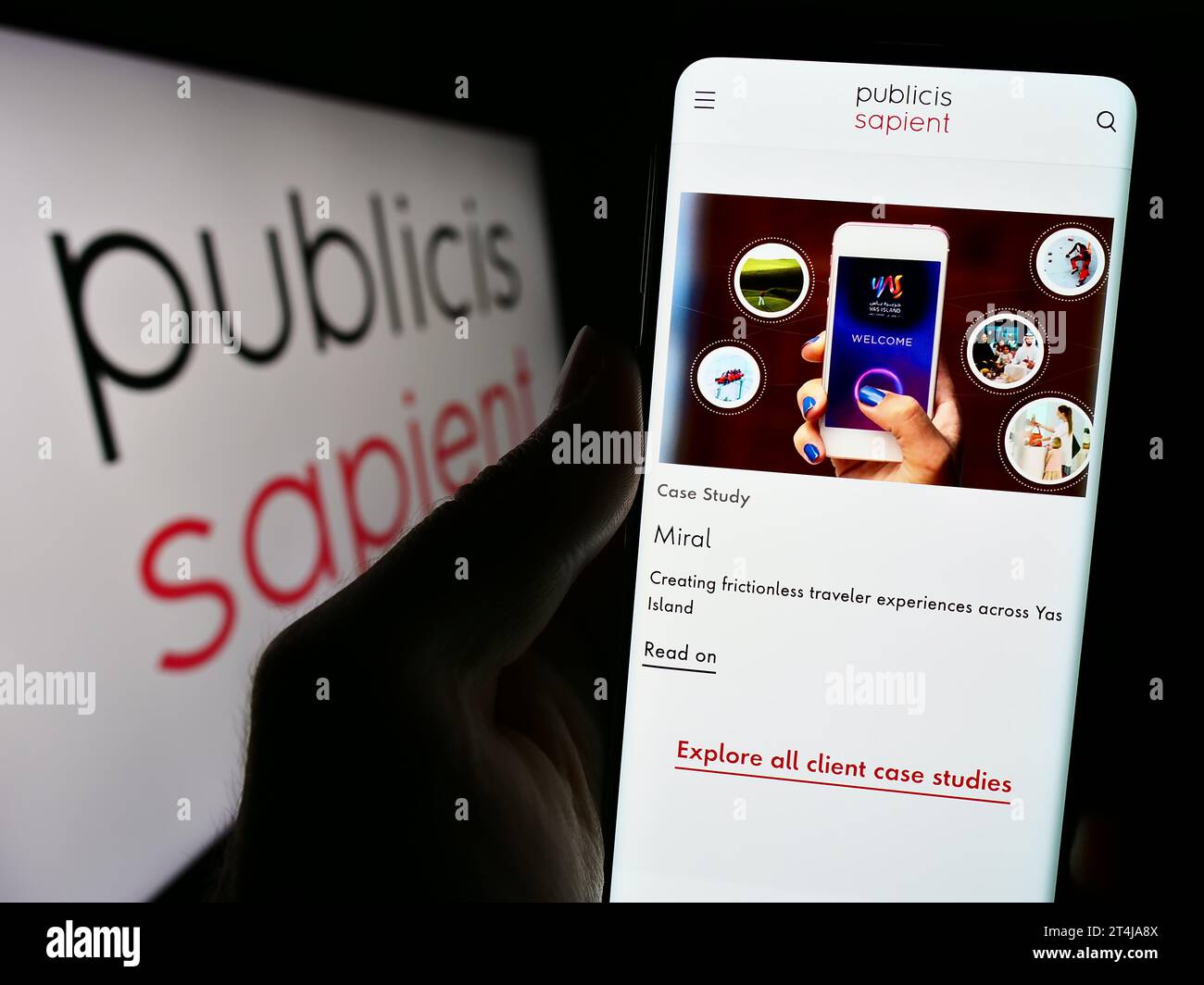 Persona che possiede uno smartphone con una pagina Web della società di consulenza digitale Publicis Sapient davanti al logo. Concentrarsi sul centro del display del telefono. Foto Stock