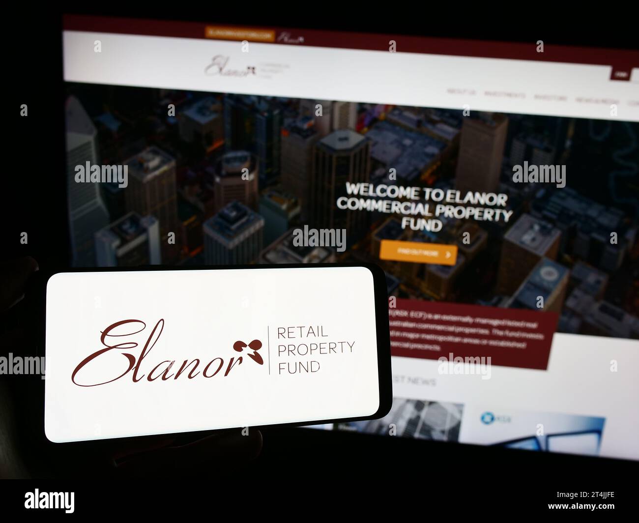 Persona che possiede uno smartphone con il logo della società australiana Elanor Commercial Property Fund davanti al sito Web. Concentrarsi sul display del telefono. Foto Stock