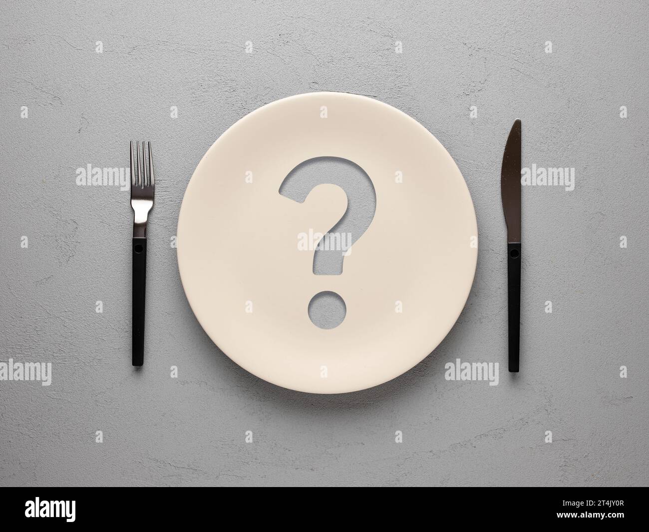 Piastra in ceramica con punto interrogativo su sfondo grigio testurizzato. Concetto di dieta e nutrizione. Che problema dovrei mangiare e mangiare nel modo giusto? Foto Stock