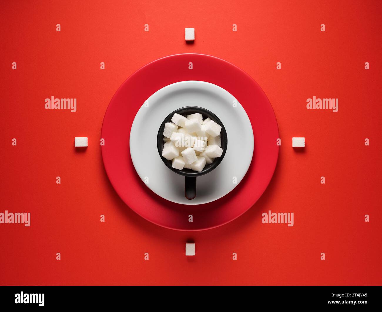 Tazza da caffè piena di cubetti di zucchero su sfondo rosso. Pausa caffè o pausa caffè. Vista dall'alto, spazio di copia. Concetto di cibo creativo. Foto Stock