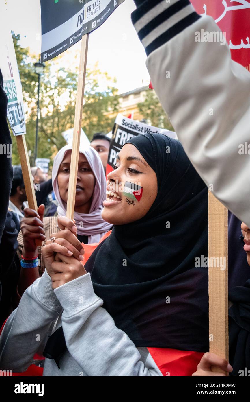 Una giovane donna con una bandiera palestinese dipinta sul suo volto alla protesta pro palestinese centrale di Londra. Foto Stock