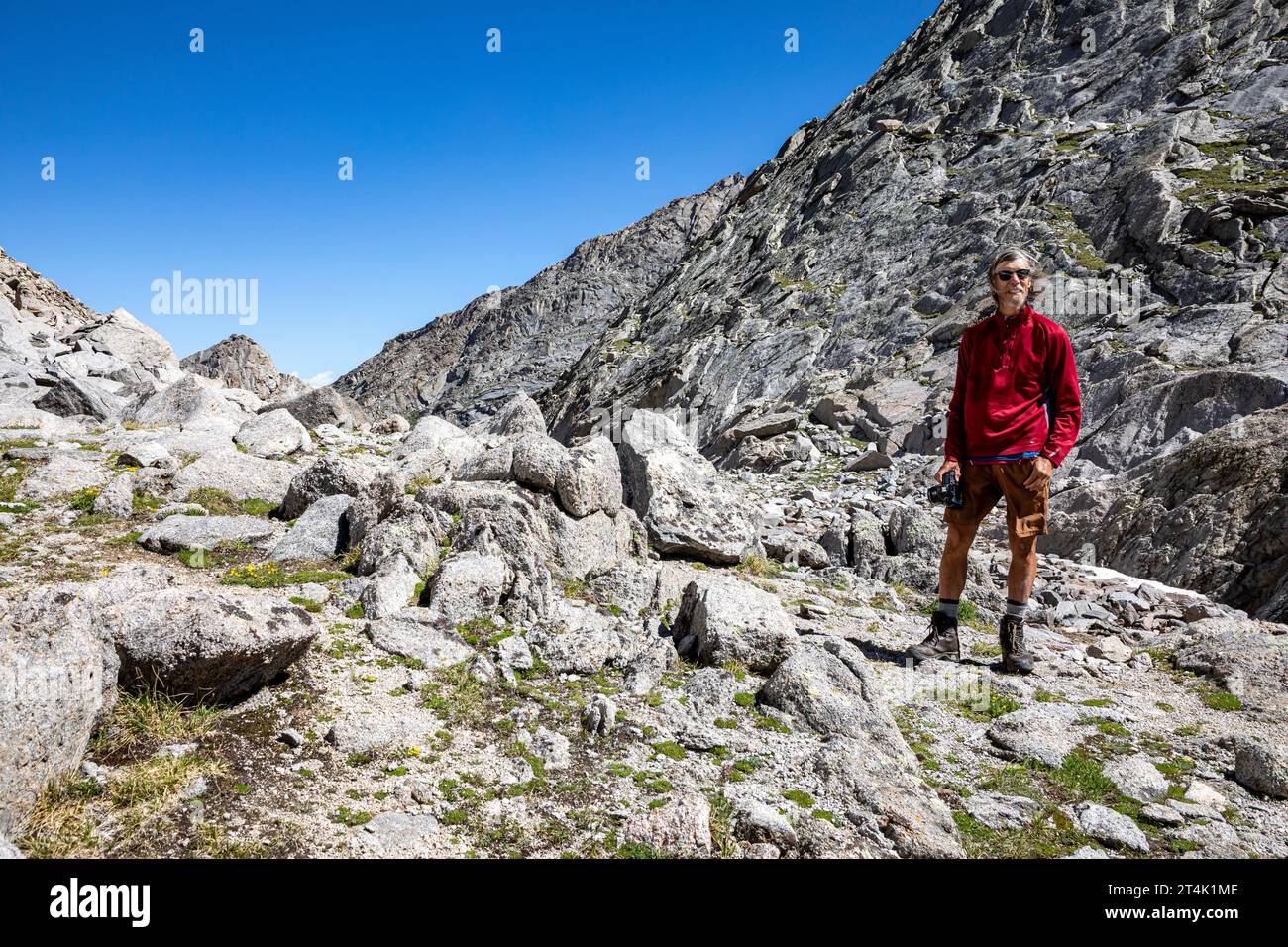 WY05531-00...WYOMING - Tom Kirkendall godendosi il paesaggio dalla cima rocciosa del Texas Pass nella zona di Popo Agie Wilderness. Foto Stock