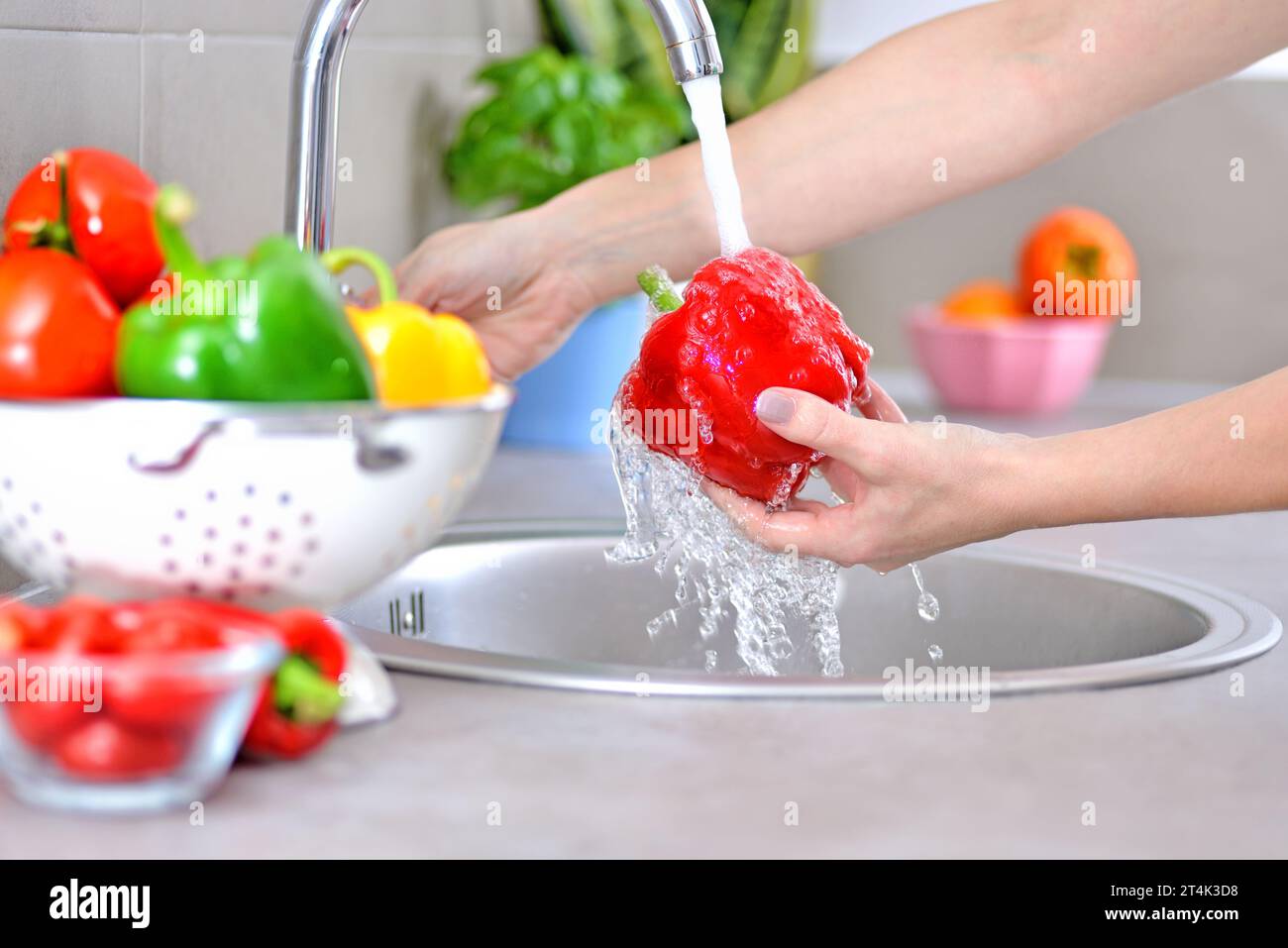 Lavare le verdure. Una donna in cucina. Foto Stock