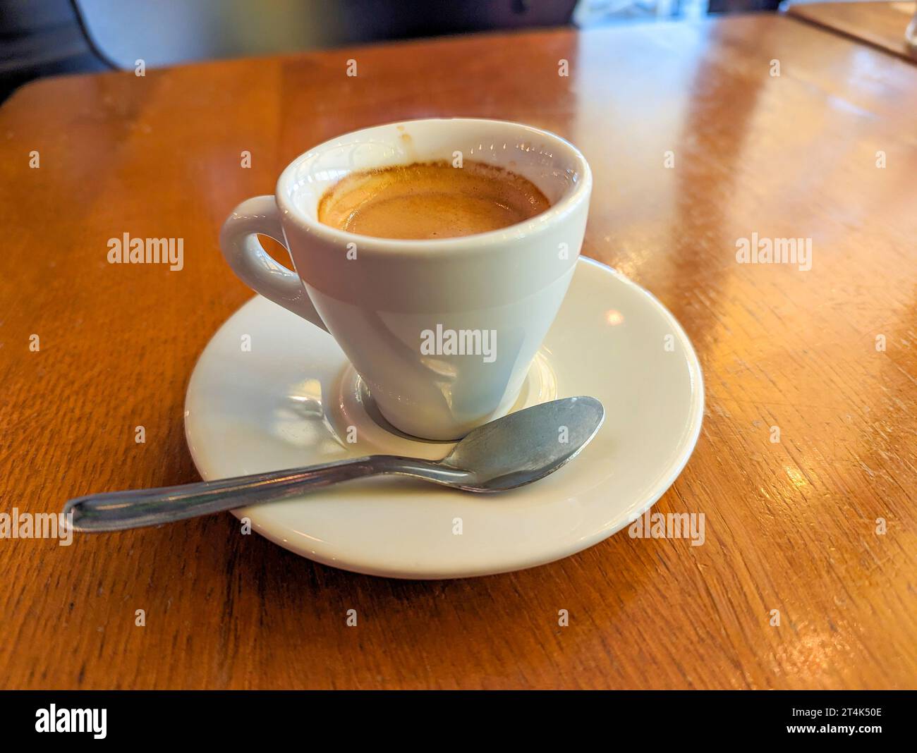Caffè espresso tradizionale servito in una tazza bianca sul tavolo di un bistro parigino Foto Stock