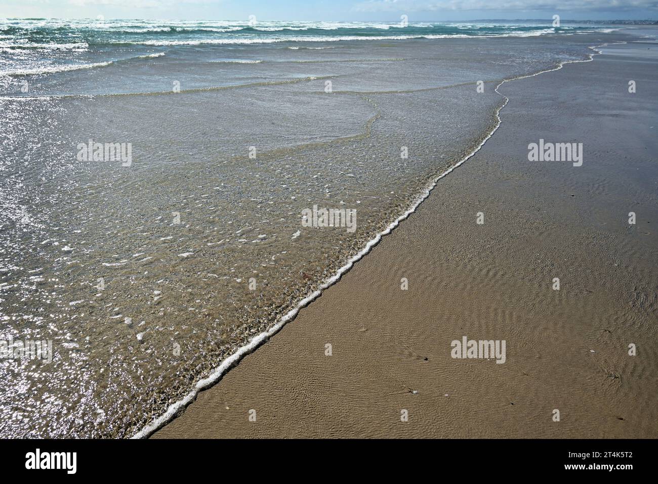 Vista ravvicinata delle onde sulla spiaggia vicino al villaggio di Plovan in Bretagna. Foto Stock