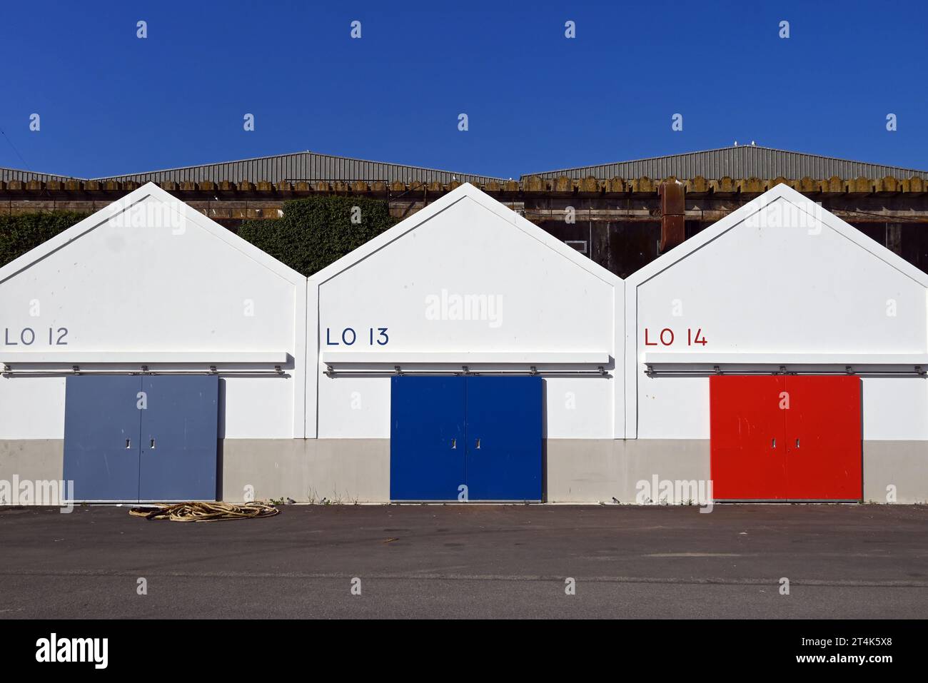 I capannoni colorati di 3 pescivendoli sulla banchina di Lorient. Bacward è l'ex base sottomarina tedesca durante la seconda guerra mondiale. Foto Stock