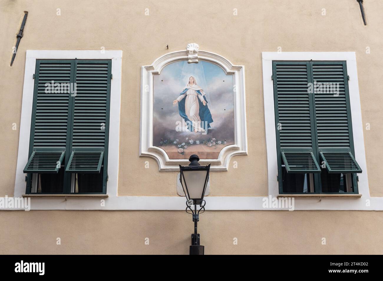 Santuario votivo con affresco della Vergine Maria tra due finestre chiuse nel centro storico di Loano, Savona, Liguria, Italia Foto Stock