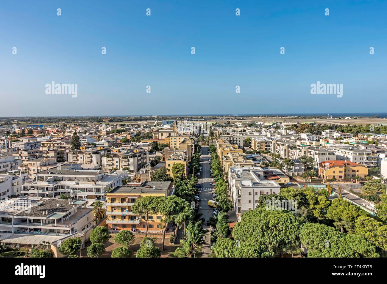 Veduta aerea di Brindisi, Italia, che mostra edifici residenziali, strade alberate e la costa adriatica sotto un cielo estivo azzurro. Foto Stock