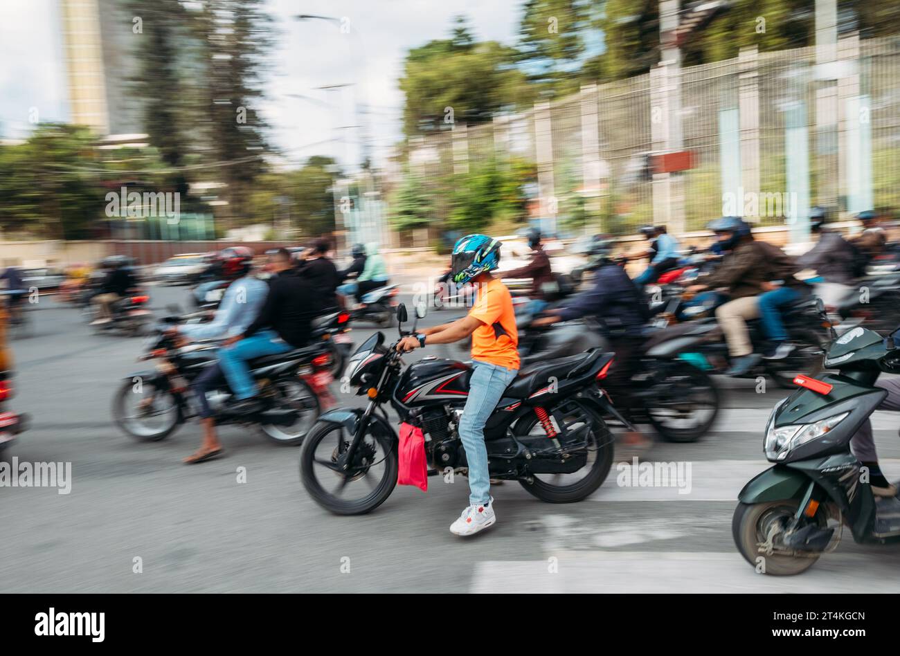 Kathmandu Urban Buzz: moto scooter nelle polverose strade nepalesi di Kathmandu, Nepal. L'inquinamento, la crescita urbana disordinata e i viaggi in Asia concepiscono Foto Stock