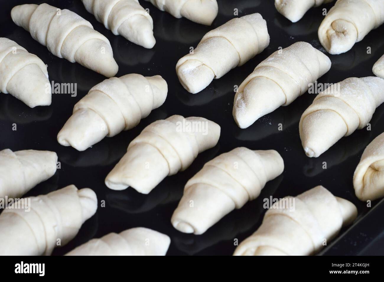 Croissant crudo su vassoio preparato per la cottura Foto Stock