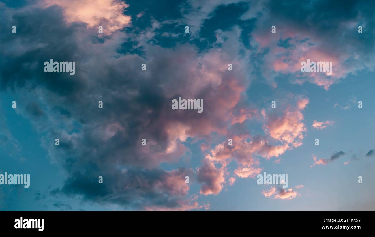 Scenografiche nuvole luminose in oro rosa, impreziosite dal tramonto. Foto aerea panoramica ravvicinata di un cielo blu profondo con nuvole di gonfi Foto Stock