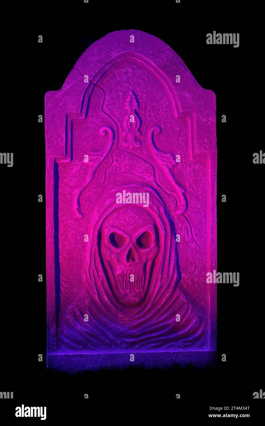 Halloween Pink, Purple e Blue Lit Tombstone con teschio che si illumina al buio Foto Stock
