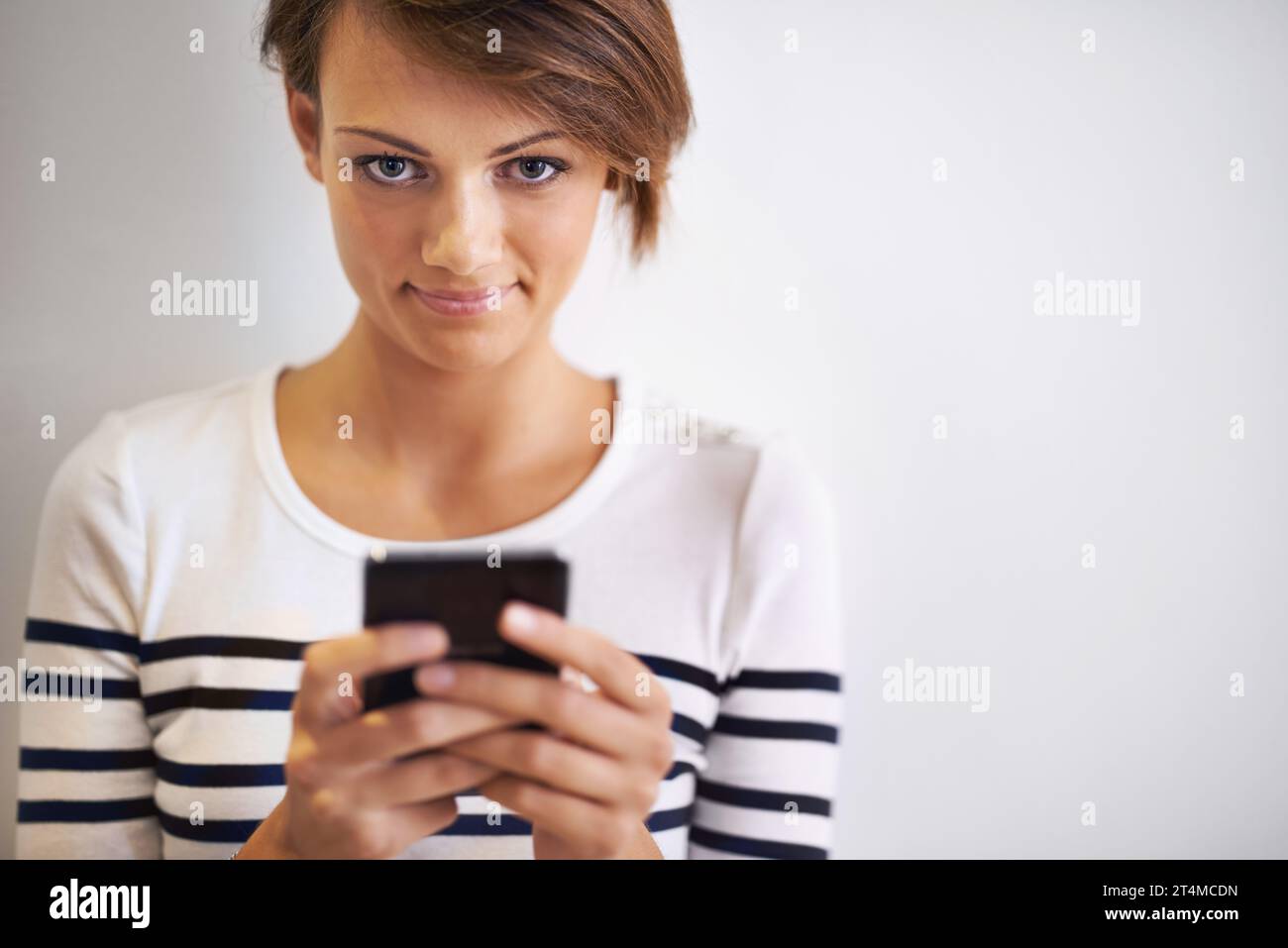 Pronti... stabile... testo. Un ritratto ritagliato di una bella giovane donna che usa uno smartphone. Foto Stock