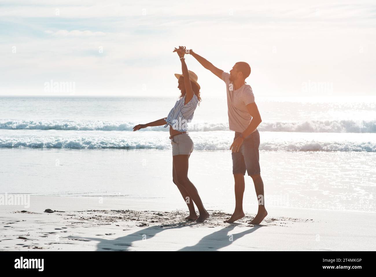 Le vere storie d'amore non hanno mai fine. una giovane coppia che danza insieme in spiaggia. Foto Stock