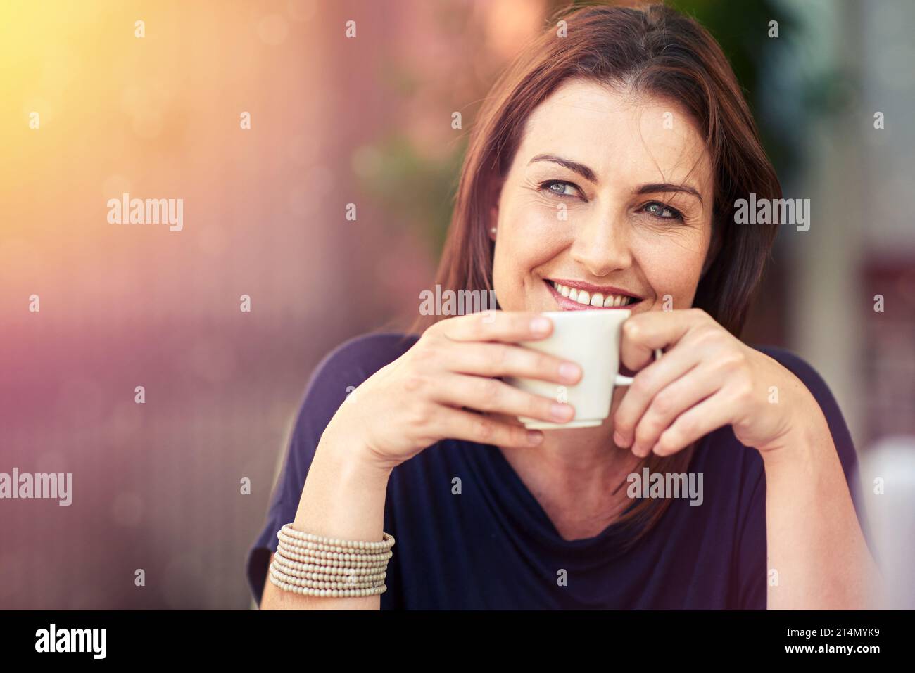 Godendosi una cuppa rilassata. una donna che beve una tazza di caffè. Foto Stock