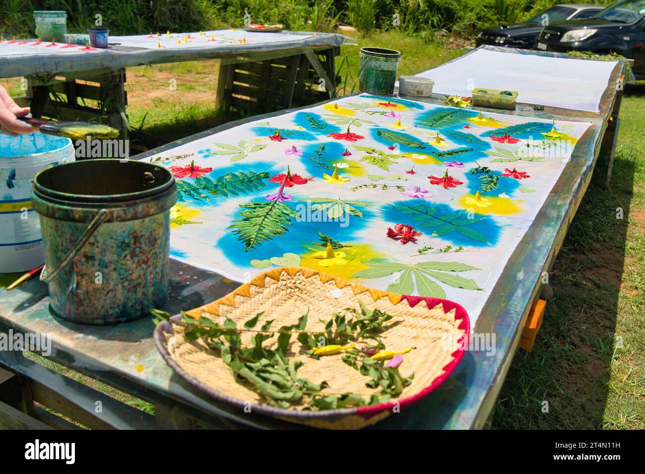 Dipingere su foglie e fiori con inchiostro per la stampa di tessuti presso il laboratorio per la sua realizzazione di pareo, Mahe Seychelles Foto Stock